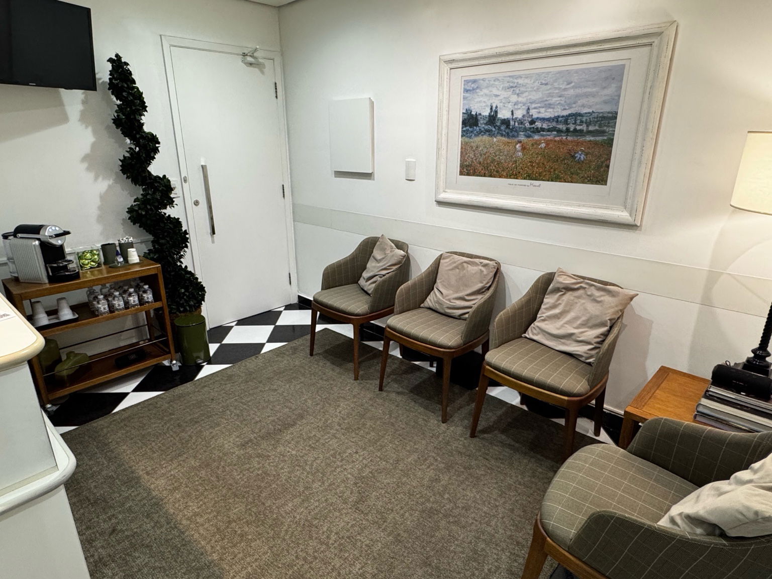 Sala de espera do consultório, com poltronas e café